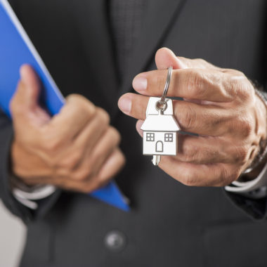 Estate agent offering keys to a new home.